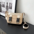 Sac bandoulière kaki minimaliste avec boucles noires et large sangle sur table - Kaki