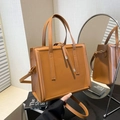 Elegante braune quadratische Tragetasche mit Ledertextur und verstellbarem Schultergurt - Braun