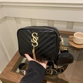 Black quilted crossbody camera bag with gold logo, tassel detail, and wide patterned strap - Black