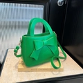 Leuchtend grüne quadratische Handtasche mit Schleife, Goldbeschlägen und Tragegriff - Grün