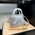 Silver bow-knot crossbody bag with metallic finish and detachable strap shown in focus - Silver