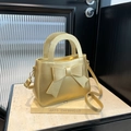 Elegant gold bow handbag with metallic finish and adjustable shoulder strap for women - Gold