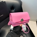 Petit sac à main rose minimaliste en similicuir avec boucle dorée porté à la main - Rose