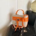Detailaufnahme der Box-Tasche aus Canvas und orangefarbenem Leder mit Quasten-Akzent - Orangerot