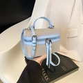 Detail of box handbag with beige woven texture, light blue leather trim and tassels - Blue