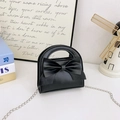 Detail einer mattschwarzen Handtasche mit Schleife, Silberkette und festem Rundgriff - Schwarz