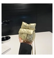 Close-up of gold quilted mini bag featuring a large bow and metallic twist lock - Gold