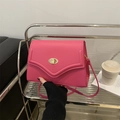 Fuchsia shoulder bag with gold turn-lock closure on a modern silver metal shelf - Rose Red