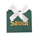 Detail of dark green Saudi gift box with white satin bow and gold palm tree logo - Green Box / White Ribbon