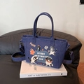 Denim tote bag with cartoon cat prints and adjustable shoulder strap on art book - Dark Blue