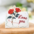 Close-up of a Love You floral card with red roses and a butterfly on a wooden tray - Rose