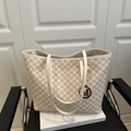 Sac cabas beige chic avec motif M marron et pendentif en métal sur chaise - Blanc