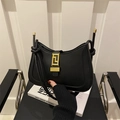 Bolso sobaco retro de cuero negro con cierre dorado en una silla minimalista - Negro