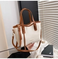 Detail der cremefarbenen Ledershopper mit braunem Rand und goldenem Schriftzug - Braun