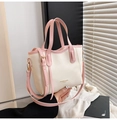 Details der schicken Handtasche in Beige und Rosa mit goldenen Beschlägen und Quaste - Rosa