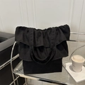 Sac fourre-tout en toile noire avec volants superposés sur un fond moderne élégant - Noir