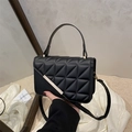 Chic black quilted leather crossbody bag with metal accent and elegant top handle - Black