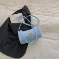 Borsa a tracolla cilindrica in denim azzurro con toppa di cane su lenzuola bianche - Blu