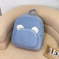 Sac à dos en molleton bleu avec oreilles d'ours et poche avant sur un canapé - Bleu