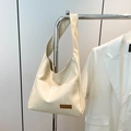 Borsa tote minimalista in pelle beige con toppa marrone appesa al supporto argento - Bianco