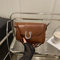 Minimalist brown leather shoulder bag featuring a unique silver U-shaped metal buckle - Dark Brown
