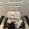 Borsa a tracolla in pelle bianca e paglia intrecciata beige con fibbia dorata su sedia - Bianco