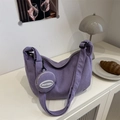 Purple corduroy crescent shoulder bag with matching round coin purse on a beige table - Purple