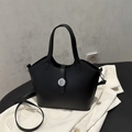 Klassische schwarze Lederbeuteltasche mit silberner Metallschnalle auf Texturhintergrund - Schwarz