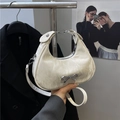 Creamy white crescent handbag featuring marble texture and a silver metal bow detail - White