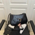 Detail of minimalist black leather shoulder bag with glossy finish and gold metal buckle - Black