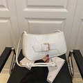 Close-up of white leather shoulder bag featuring a decorative golden buckle and knot detail - White