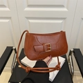 Detail of a brown leather shoulder bag featuring a gold square buckle and a knotted strap - Brown