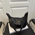 Bolso hobo media luna negro de moda con correa ancha de hombro sobre un libro - Negro