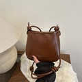 Borsa a sella vintage marrone in pelle lucida con tracolla annodata e forma rotonda - Marrone
