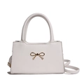 Elegant white leather crossbody bag featuring a chic golden bow accent and dual handles - White