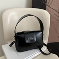 Bolso bandolera chic de cuero charol negro con logo plateado sobre un libro blanco - Negro