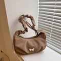 Brown canvas hobo bag with silver butterfly buckle and ruched cloud handle on white window - Khaki