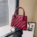 Classic dark red quilted leather handbag with gold hardware and top handle design - Red
