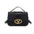 Black leather handbag with gold V-buckle closure and adjustable strap on white background - Black