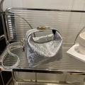 Silver snake-print shoulder bag with gold hardware and removable strap on a shelf - Silver