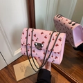Pink crossbody bag with red cherry print and grey metal chain strap in a studio mirror view - Pink