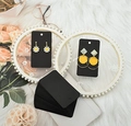 Detail of black kraft paper earring display cards with floral and round stud earrings - Black
