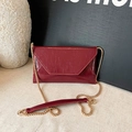 Glänzende weinrote Briefumschlag-Tasche mit goldener Kette und faltiger Textur - Rot