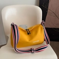 Chic yellow canvas tote bag with striped shoulder strap on a white chair in a modern setting - Yellow