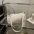 Sac baguette blanc à motif crocodile avec fermeture éclair sur un support minimaliste - Blanc