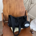 Minimalist black cylinder crossbody bag with wide strap and circular coin purse detail - Black