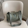 Dettaglio della borsa tote in nylon verde salvia con tracolla su sedia bianca - Verde