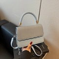 Light blue crossbody bag with woven texture flap and wavy edges on design book - Blue