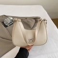 Creamy crescent shoulder bag featuring a silver metal bow accent and smooth leather finish - Glaze Apricot