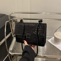 Glänzende schwarze Schultertasche mit Krokodilmuster und silberner Metallschnalle - Schwarz